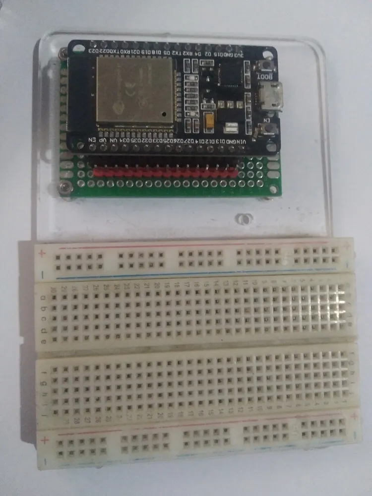 An ESP32 DevKit board with pin labels visible, seated on a breadboard