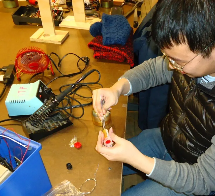 A student soldering a component connection at a workbench
